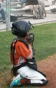 catcher: young baseball catching on his knees waiting for a game to start