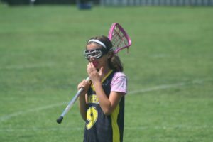 Sports Injuries: A young lacrosse player has proper eye protection and mouthguard in place