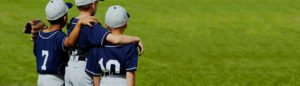 Baseball safety: young players arm in arm as they stand on a baseball field