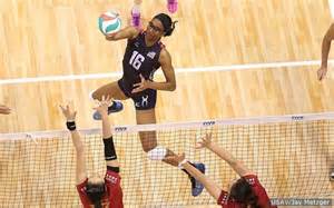 volleyball player spiking ball past two opponents