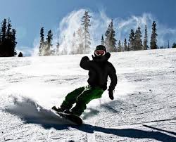 Extreme Sports Safety: snowboarder wearing helmet and goggles goes down a hill