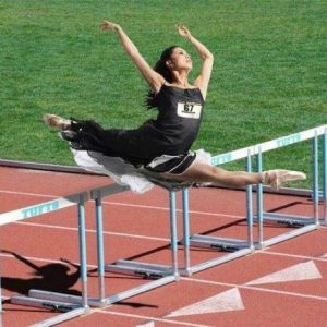 Should dancers take PE class: a dancer runs over hurdles on a track