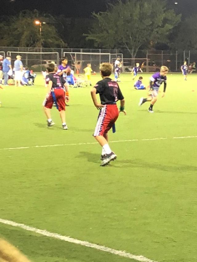 Exercise when sick: boy runs backward while playing in a flag football game