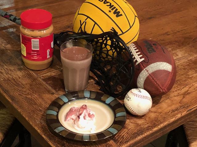 Protein: Picture of chocolate milk, yogurt and peanut butter next to a football, baseball and lacrosse stick