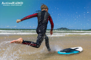 active kid skim boarding fast speeds in shallow water